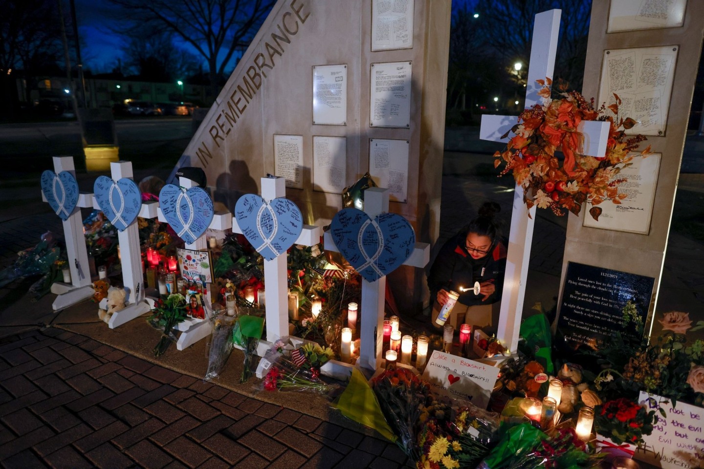Eine Frau zündet Kerzen an einer Gedenkstätte im Veteran's Park für die Opfer an, nachdem ein Geländewagen am Sonntag in eine Weihnachtsparade gerast war, bei der mehrere Menschen getöt...