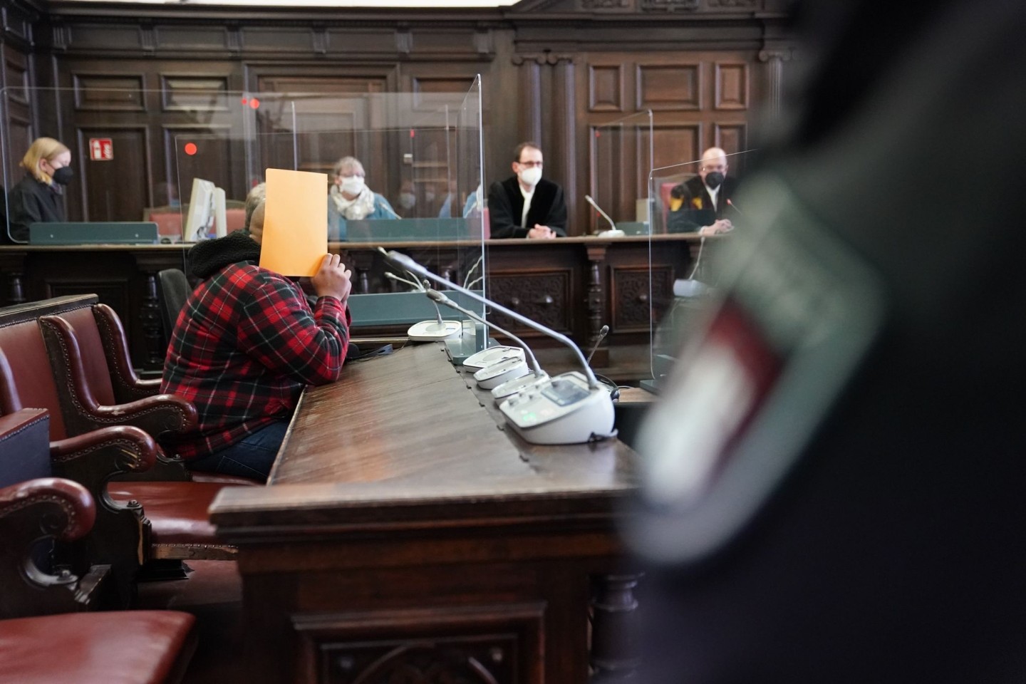 Der Angeklagte (vorne links) sitzt im Gericht.