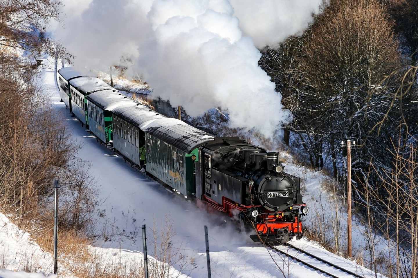 Die Fichtelbergbahn schnauft durch den Winterwald im Erzgebirge.